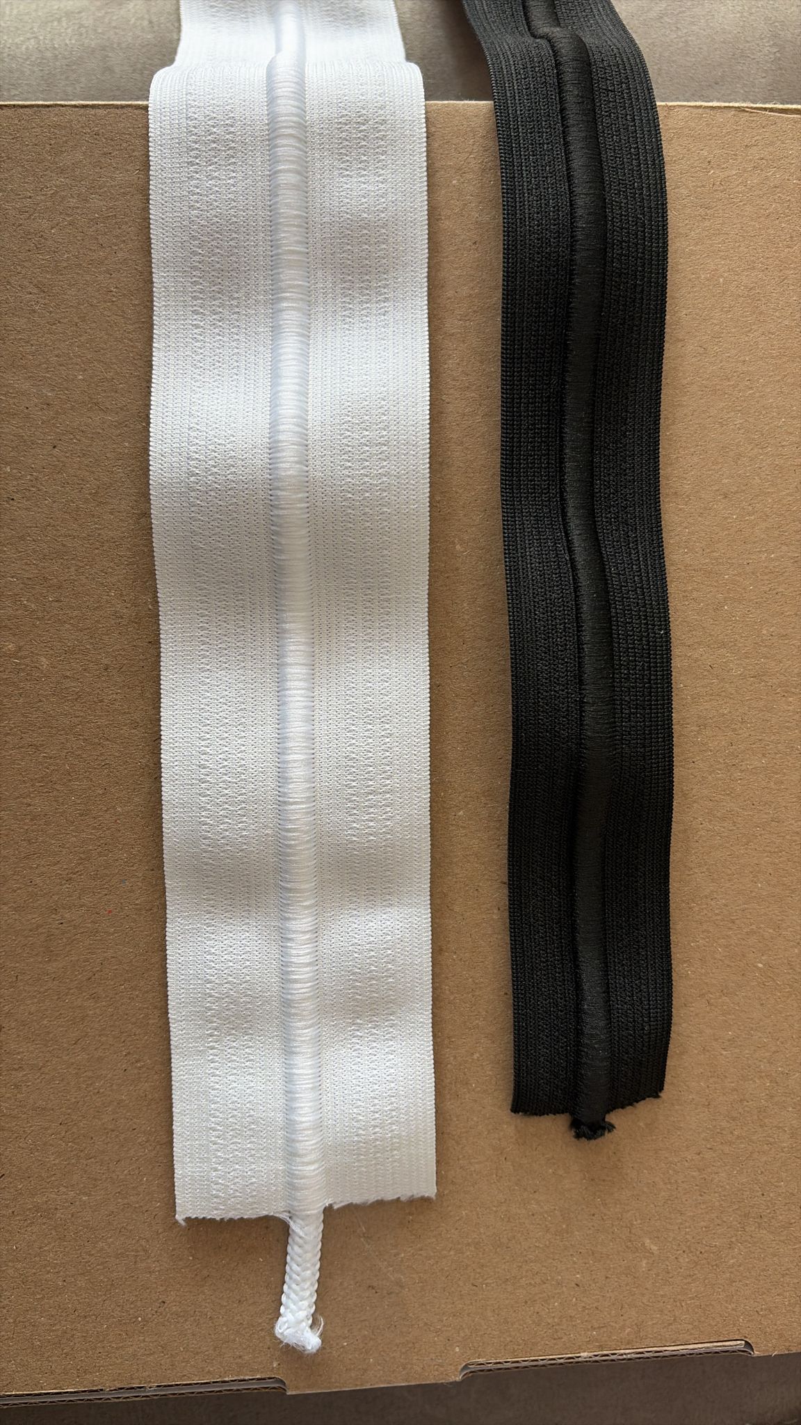 White and black elastic trim for garment and upholstery use, showcasing textured fabric and durability.